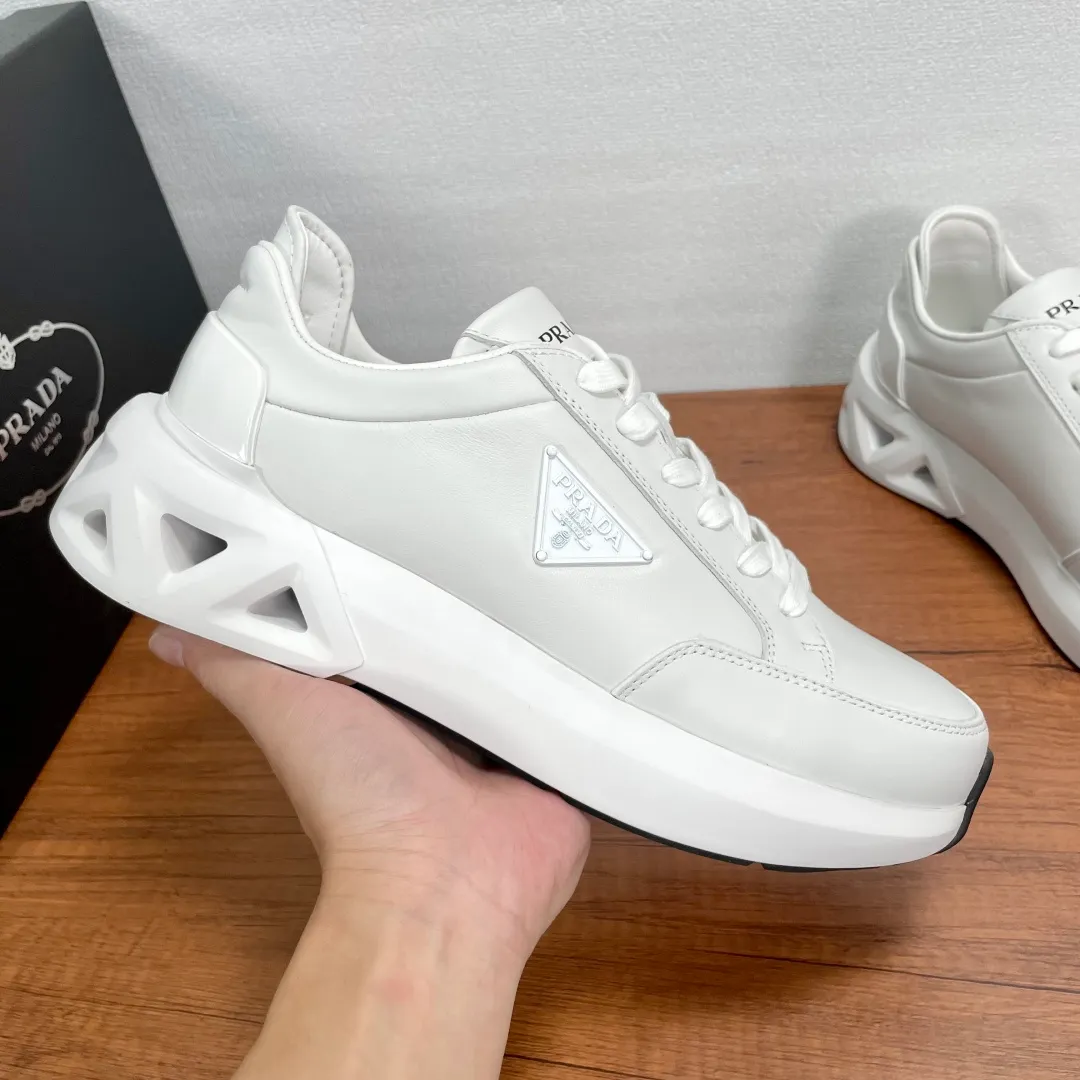 💰780 Code: YS003645 Prada/Prada men's new leather sneakers. This leather sneaker presents a modern version, reinterpreting the brand's archive style with clean lines and smooth details. The shoes are made of imported calf leather, which is fine, soft and resistant to creases. It is decorated with a triangular metal logo on the outside, bright TPU decoration on the heel, and a longer and padded inner heel design, making it more comfortable to wear. The tongue is decorated with a silk-screen logo, and is paired with a hollow rubber sole on the heel. The full cowhide lining comes standard with logo cowhide feet, making the upper foot more comfortable, versatile and durable! Comes with full original packaging! Code number: 39-40-41-42-43-44 Standard leather shoe size (45 can be customized and does not support returns) Item number: 2EE918 leather white